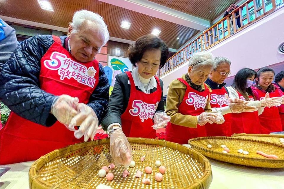 宜蘭縣長林姿妙（左二）今天邀請秘克琳神父（左一）等人參與就職5周年活動，正逢冬至，眾人一起搓湯圓，還與縣府員工們一起分享、品嘗。（李忠一攝）