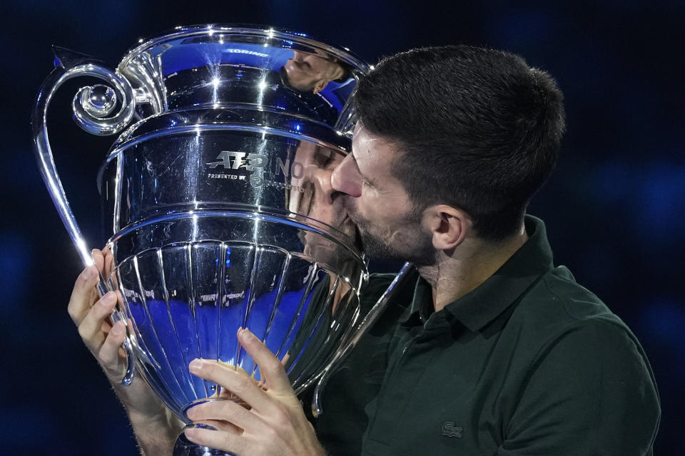 Serbia's Novak Djokovic kisses the trophy as ATP world best player at the ATP World Tour Finals, at the Pala Alpitour, in Turin, Italy, Monday, Nov. 13, 2023. Djokovic was presented with the trophy for finishing the year ranked No. 1. (AP Photo/Antonio Calanni)