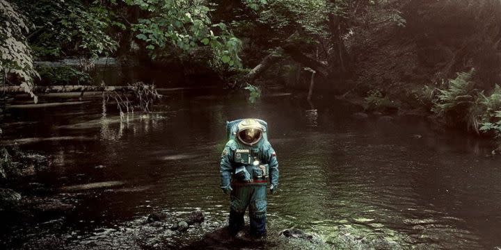 Adam Sandler walks through a jungle in Spaceman