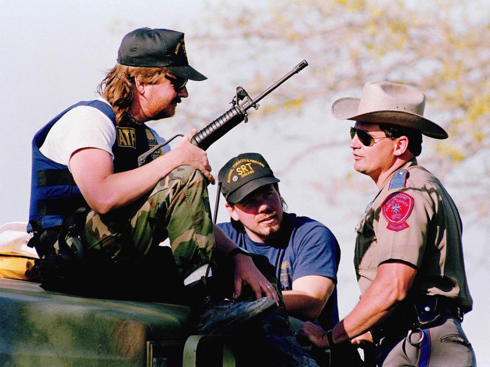 Officers talk with an ATF agent outside the Branch Davidian compound on April 1.