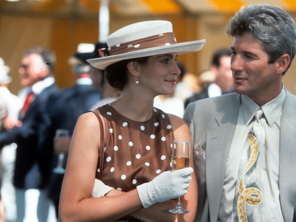 A still from "Pretty Woman" of Julia Roberts in a brown polka dot dress and Richard Gere in a gray suit