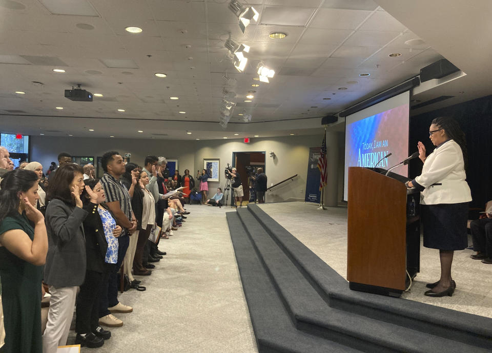 Denise Frazier, Atlanta district director for U.S. Citizenship and Immigration Services, administers the oath of allegiance to 99 new American citizens gathered at The Carter Center, Sunday, Oct. 1, 2023, in Atlanta, on former President Jimmy Carter's 99th birthday. (AP Photo/Bill Barrow)