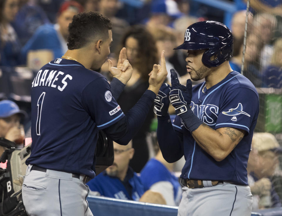 Tampa Bay Rays' Tommy Pham, right, is greeted by Willy Adames (1) after he hit a two-run home run against the Toronto Blue Jays in the third inning of a baseball game in Toronto on Friday, Sept. 27, 2019. (Fred Thornhill/The Canadian Press via AP)