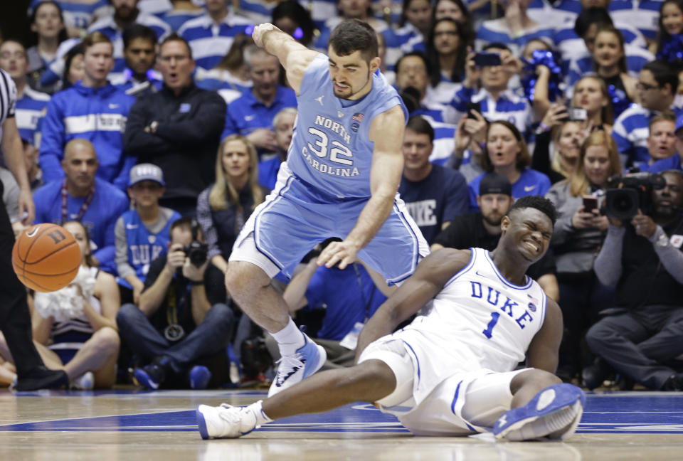 Duke's Zion Williamson (1) falls to the floor with an injury while chasing the ball with North Carolina's Luke Maye (32) during the first half of an NCAA college basketball game in Durham, N.C., Wednesday, Feb. 20, 2019. (AP Photo/Gerry Broome)