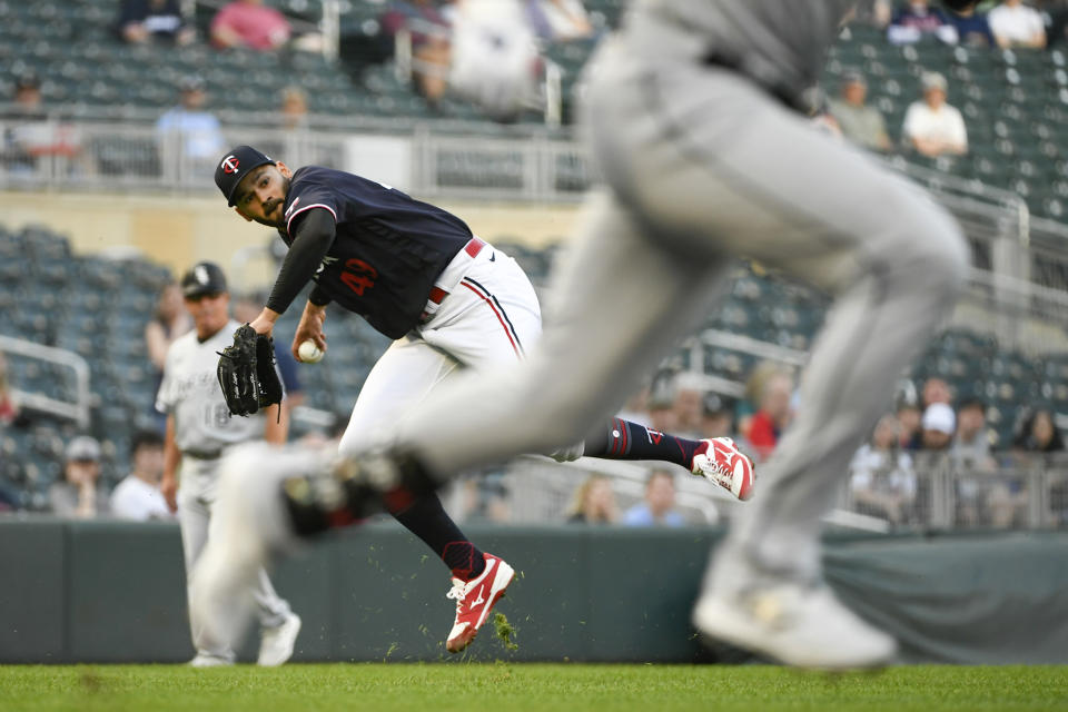 Minnesota Twins pitcher Pablo Lopez looks to throw to first after fielding a short ground ball hit by Chicago White Sox's Luis Robert during the first inning of a baseball game Tuesday, April 11, 2023, in Minneapolis. Robert advanced to second on a throwing error by Lopez. (AP Photo/Craig Lassig)