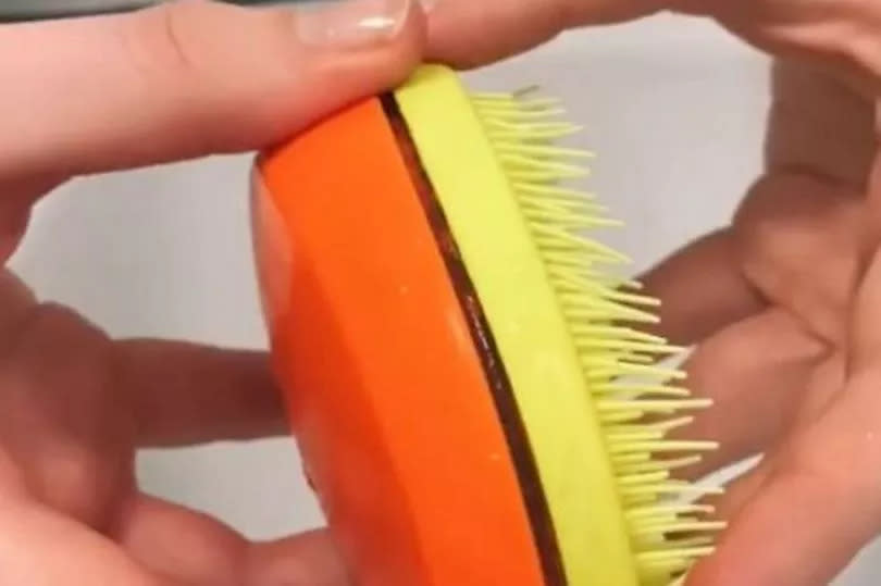 Tangle Teezer brush being opened to reveal dirt inside