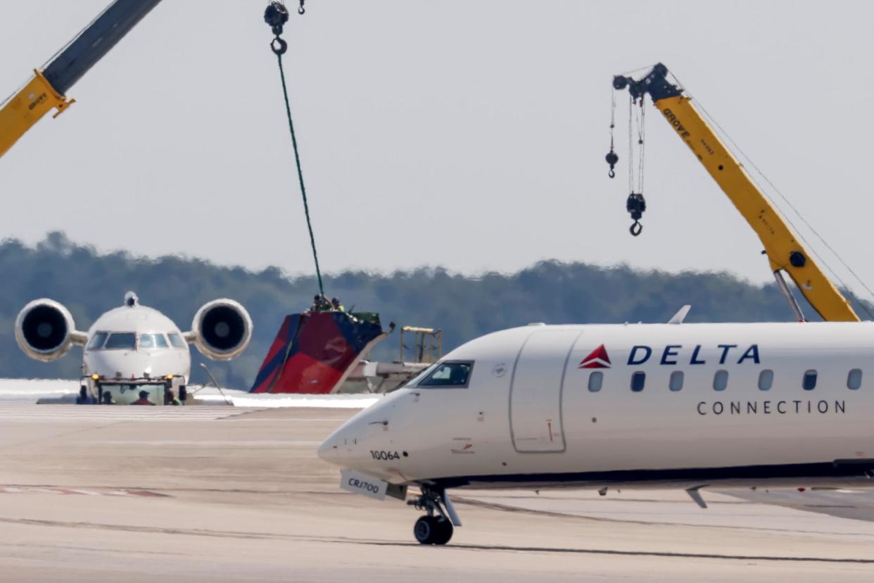 <span>Workers secure the tail section of an Endeavor Air aircraft after a collision with a Delta jet at the Atlanta airport on Wednesday.</span><span>Photograph: Erik S Lesser/EPA</span>