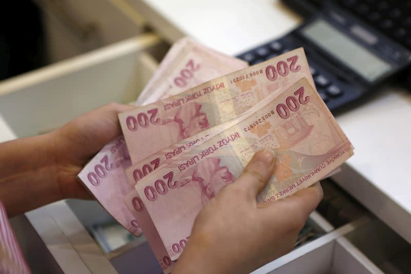 FILE PHOTO: A money changer counts Turkish lira bills at an currency exchange office in central Istanbul, Turkey