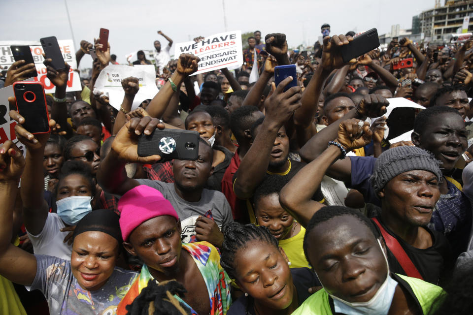 People hold banners as they demonstrate on the street to protest against police brutality in Lagos, Nigeria, Thursday Oct. 15, 2020. Protests against Nigeria's police continued to rock the country for the eighth straight day Thursday as demonstrators marched through the streets of major cities, blocking traffic and disrupting business. (AP Photo/Sunday Alamba)