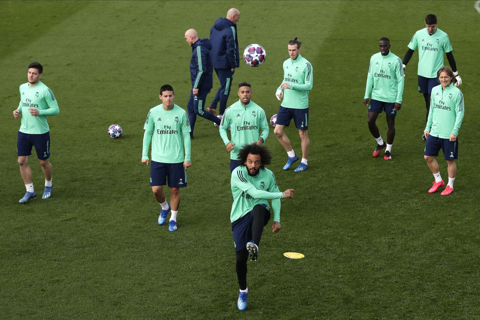 Real Madrid's Marcelo, center, kicks the ball during a training session at the team's Valdebebas training ground in Madrid, Spain, Tuesday, Feb. 25, 2020. Real Madrid will play against Manchester City in a Champions League soccer match on Wednesday. (AP Photo/Manu Fernandez)