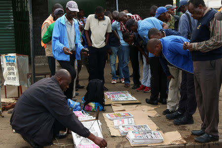 Locals read newspaper headlines in Harare, Zimbabwe, January 17, 2019. REUTERS/Philimon Bulawayo