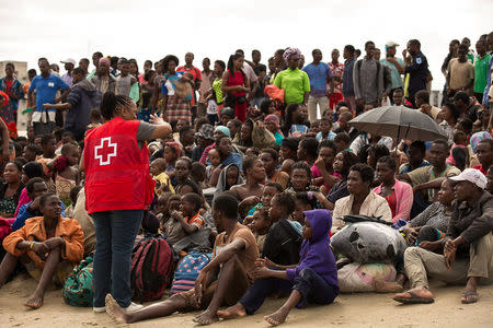 Survivors of Cyclone Idai, listen to a volunteer from Mozambique Red Cross, after arriving to an evacuation centre in Beira, Mozambique, March 21, 2019. Denis Onyodi/Red Cross Red Crescent Climate Centre/Handout via REUTERS
