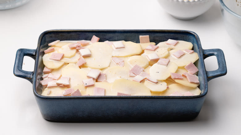 assembling potato and ham gratin