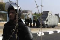 Riot policemen stand guard outside the police academy, where ousted Egyptian president Mohamed Mursi's trial took place, on the outskirts of Cairo, November 4, 2013. Mursi struck a defiant tone on the first day of his trial on Monday, chanting 'Down with military rule', and calling himself the country's only 'legitimate' president. Mursi, an Islamist who was toppled by the army in July after mass protests against him, appeared angry and interrupted the session repeatedly, prompting a judge to adjourn the case. REUTERS/Amr Abdallah Dalsh (EGYPT - Tags: POLITICS CIVIL UNREST)