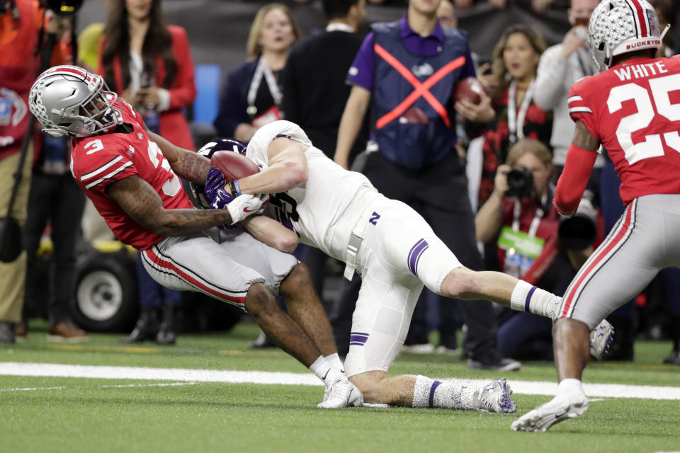 Northwestern wide receiver Charlie Fessler begins to fumble as he is tackled by Ohio State cornerback Damon Arnette (3) during the second half of the Big Ten championship NCAA college football game, Saturday, Dec. 1, 2018, in Indianapolis. After review, Fessler was ruled down before the fumble and Northwestern maintained in position of the ball. (AP Photo/Michael Conroy)