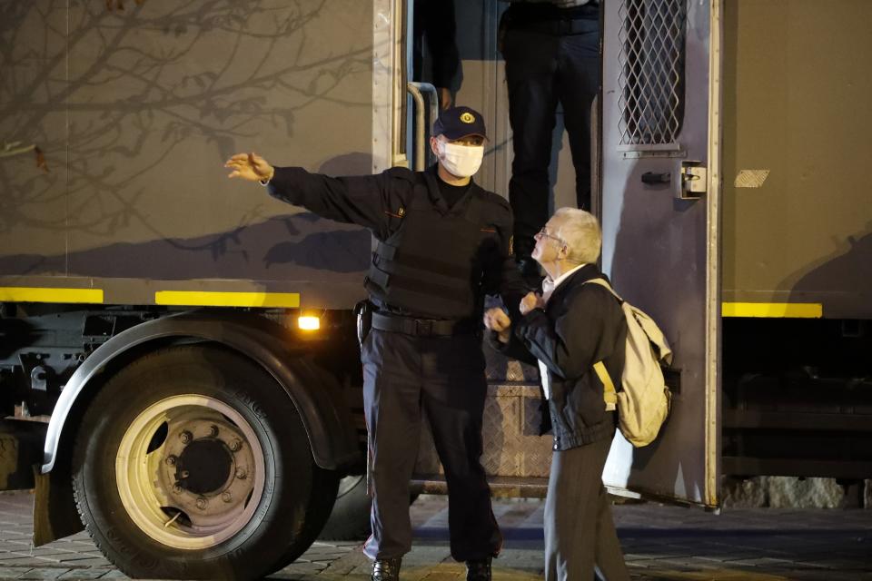 A police officer gestures as he talks with opposition activist Nina Baginskaya, 73, right, during a Belarusian opposition supporters rally at Independence Square in Minsk, Belarus, Wednesday, Aug. 26, 2020. Protests demanding the resignation of Belarus' authoritarian President Alexander Lukashenko have entered their 18th straight day on Wednesday. (AP Photo/Dmitri Lovetsky)