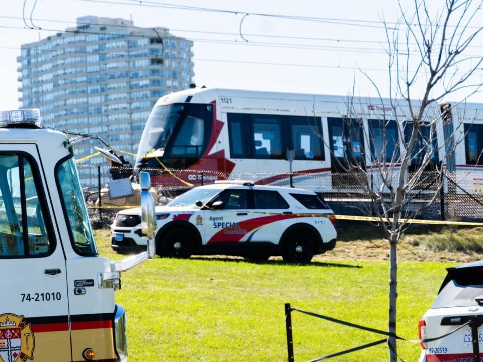 Emergency vehicles are parked near the scene of the Sept. 19 derailment near Tremblay station. City manager Steve Kanellakos says it's now expected full service on the Confederation Line will resume no earlier than the middle of December. (Nicholas Cleroux/Radio-Canada - image credit)