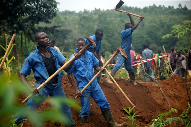 Burundian workers from the Truth and Reconciliation Commission dig to extract bodies from a mass grave in the Bukirasazi hill in Karusi Province