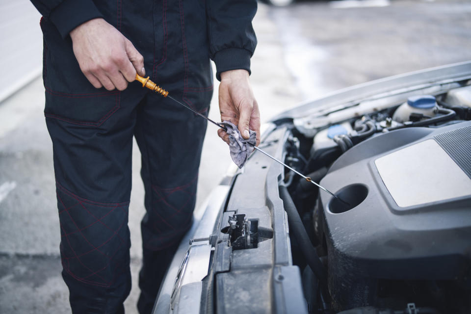 Person checking the oil in a car