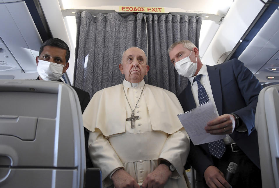 Pope Francis greets the journalists onboard the papal plane on the occasion of his five-day pastoral visit to Cyprus and Greece, Monday, Dec. 6, 2021. Francis' five-day trip to Cyprus and Greece has been dominated by the migrant issue and Francis' call for European countries to stop building walls, stoking fears and shutting out "those in greater need who knock at our door." (Alessandro Di Meo/Pool photo via AP)
