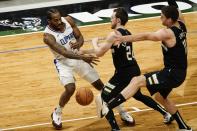 Milwaukee Bucks' Brook Lopez kicks a ball thrown by LA Clippers' Kawhi Leonard during the first half of an NBA basketball game Sunday, Feb. 28, 2021, in Milwaukee. (AP Photo/Morry Gash)