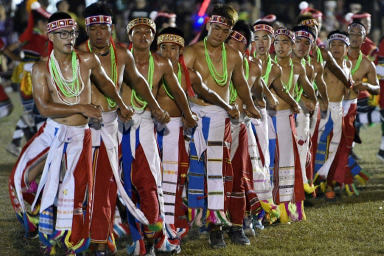 Men from Taiwan's Amis indigenous group dance in embroidered skirts and feathered head dresses as part of an ancient match-making ritual