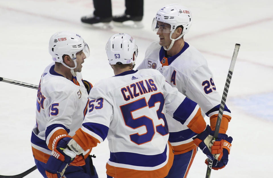 New York Islanders' Brock Nelson (29) celebrates after his empty-net goal with teammates Cal Clutterbuck (15) and Casey Cizikas (53) during third-period NHL hockey game action against the Ottawa Senators in Ottawa, Ontario, Monday, Nov. 14, 2022. (Patrick Doyle/The Canadian Press via AP)