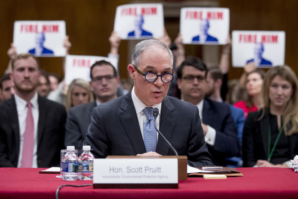 Members of the audience hold up signs that read “Fire Him” as Pruitt testifies before a Senate subcommittee on May 16, 2018. (Photo: Andrew Harnik/AP)