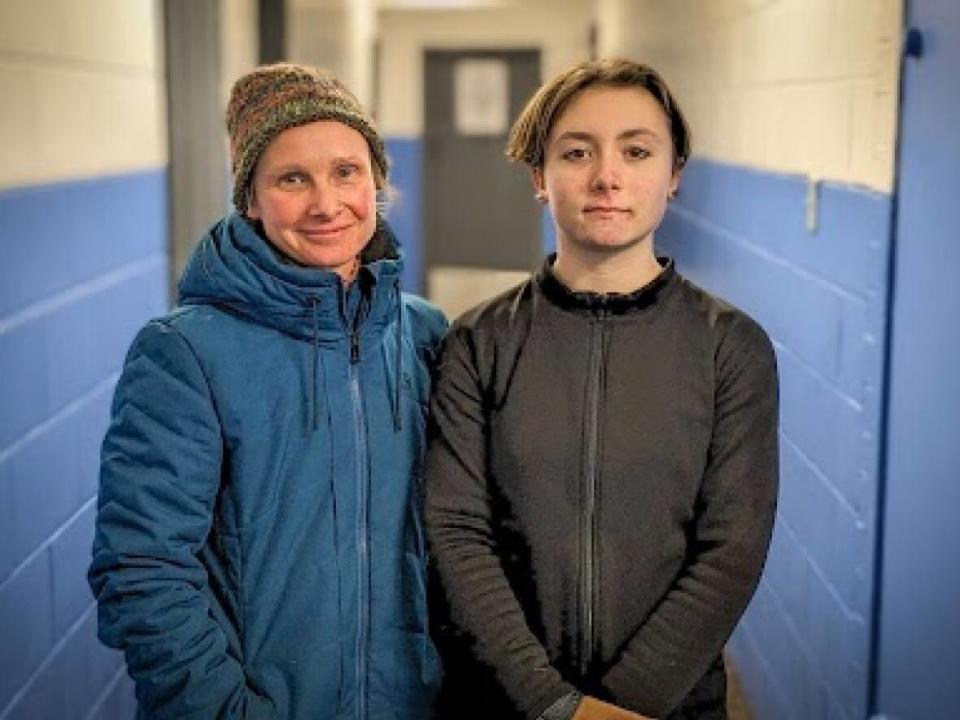 Rebecca Reed-Jones (left) and Rowyn in the hallway at Simmons Arena, where the figure skaters train.   (Shane Hennessey/CBC  - image credit)