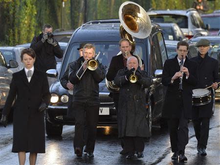 A band plays in the funeral cortege of Ronnie Biggs as it arrives at Golders Green Crematorium in north London January 3, 2014. REUTERS/Toby Melville