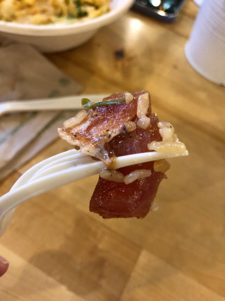 A piece of raw, red ahi poke on a fork at Poke Papa