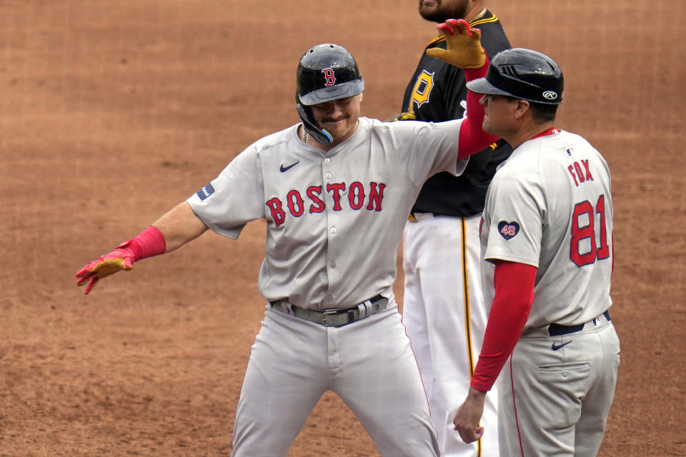 CORRECTS TO FIFTH INNING NOT FIRST INNING - Boston Red Sox's Reese McGuire, left, celebrates on first base after driving in two runs with a single off Pittsburgh Pirates relief pitcher Ryder Ryan (not shown) during the fifth inning of a baseball game in Pittsburgh, Sunday, April 21, 2024. (AP Photo/Gene J. Puskar)
