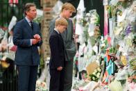 <p>Prince William, Prince Harry, and their father visit memorial tributes to Princess Diana outside of Kensington Palace the week after she died in a car accident in Paris.</p>