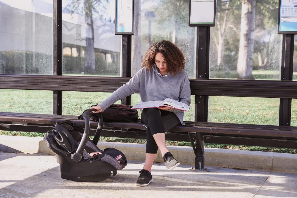 In this stock photo, a college student waits at a public transit stop. About one in four community or technical college campuses in Florida aren't accessible via public transit, according to new research from the Seldin Haring-Smith Foundation.