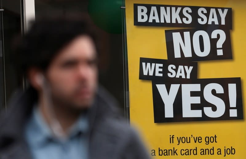 FILE PHOTO: A pedestrian walks past a payday lending shop in London