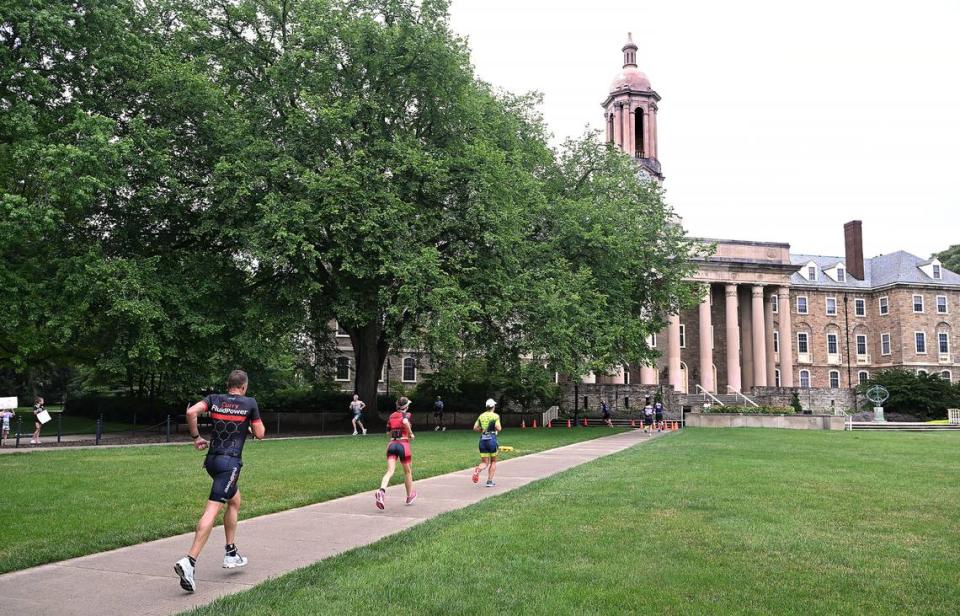 Participants in the Ironman 70.3 Pennsylvania Happy Valley triathlon run past Old Main on the Sunday on the Penn State campus.