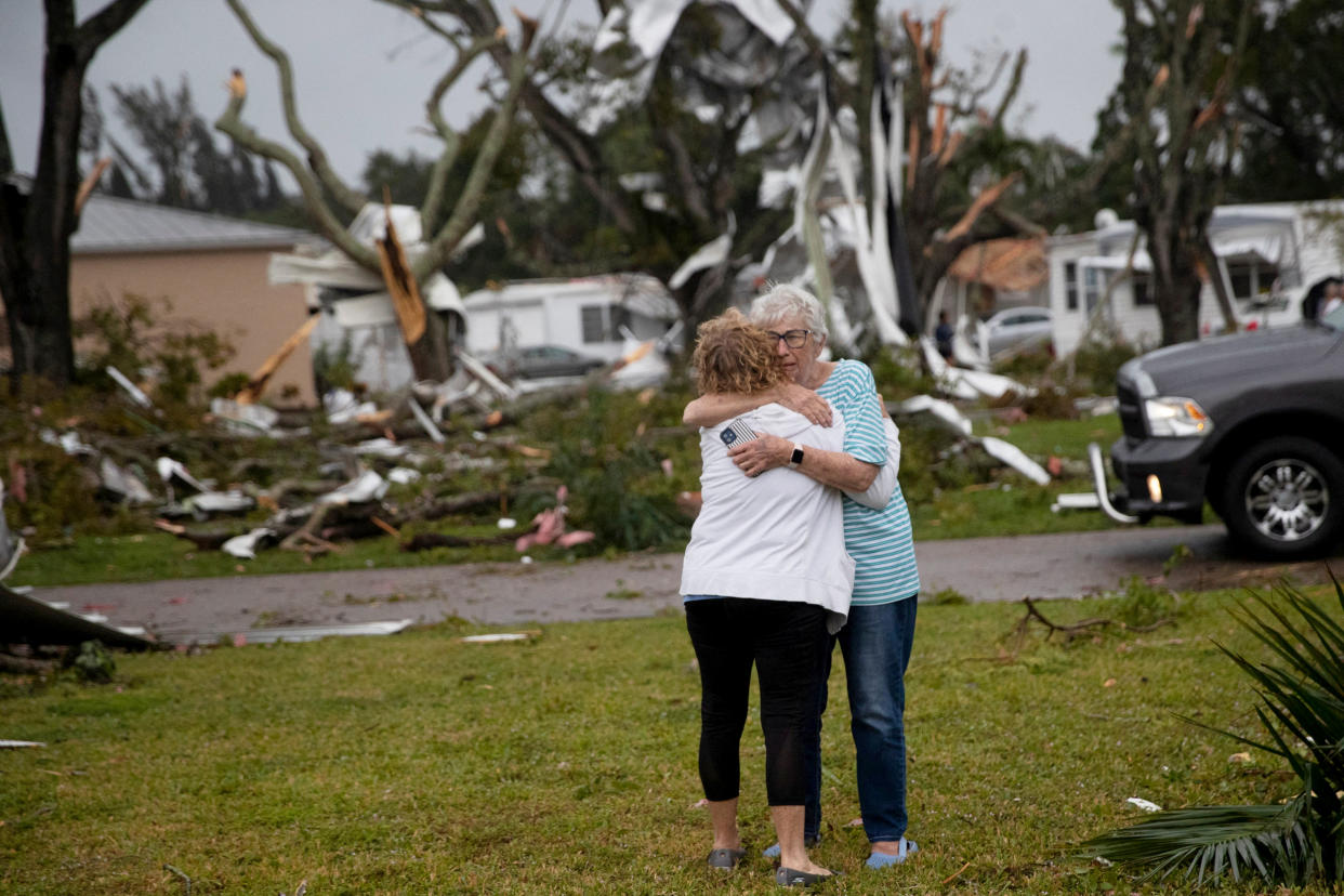 Image: Residents of Century 21 in the Iona area embrace after a tornado touched down in Fort Myers (Andrew West / Reuters)