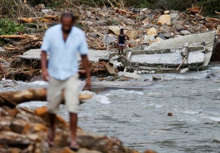 A man stands on top of the debris of a house at a landslide site during a rescue mission in Athwelthota village, in Kalutara, Sri Lanka May 28, 2017. REUTERS/Dinuka Liyanawatte