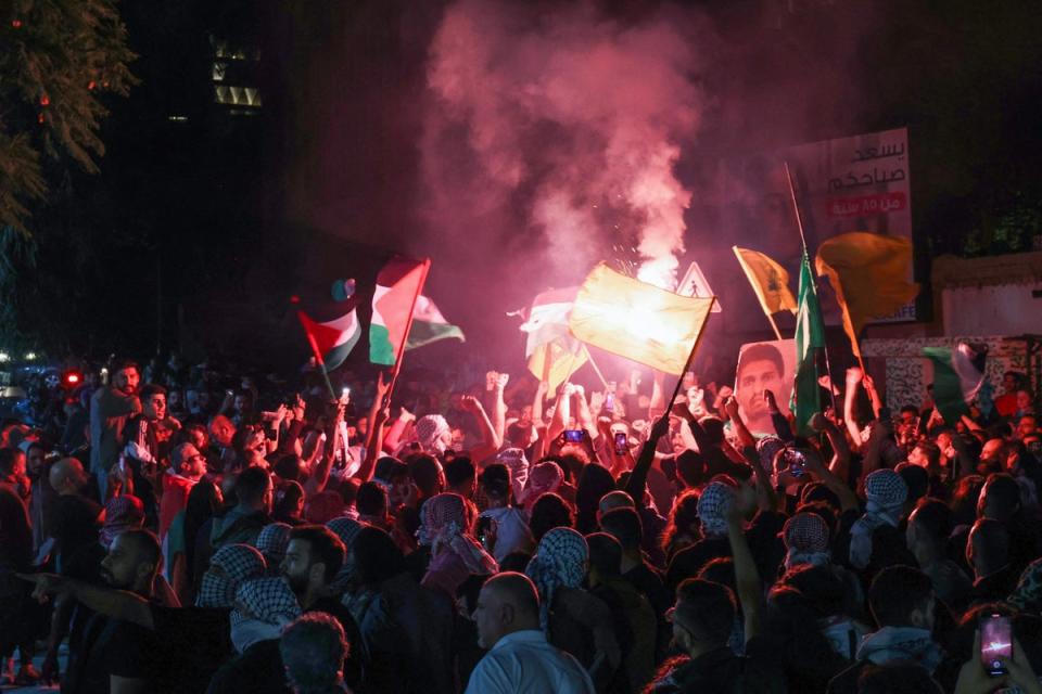 Protesters lift Palestinian flags and a portrait of Mohammed Deif chief of Al-Qassam Brigades, Hamas' military wing, during rally at the entrance of the French embassy complex in Beirut (AFP via Getty Images)