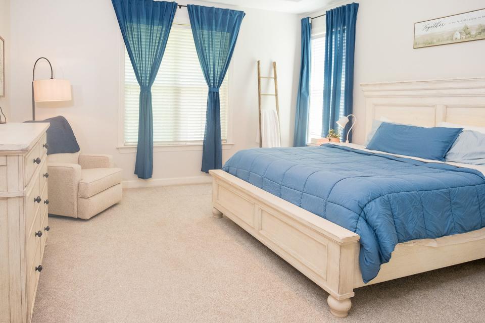 The primary bedroom sports a classic color combination of blue and white.