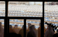 UAE officials are seen from behind a glass door as they look from a balcony at the Shams 1, Concentrated Solar power (CSP) plant, in al-Gharibiyah district on the outskirts of Abu Dhabi. (MARWAN NAAMANI/AFP/Getty Images)