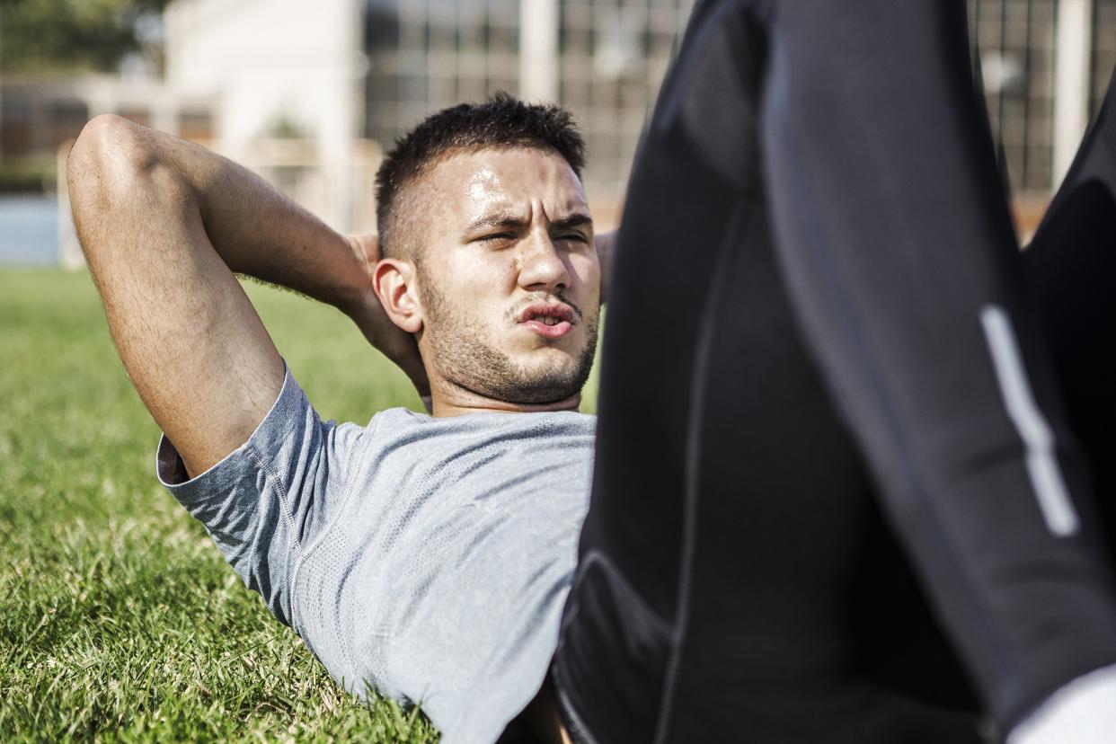 man doing crunches outside