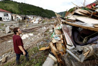 A man looks at his parents' house hit by heavy rain in Kuma village, Kumamoto prefecture, southern Japan Wednesday, July 8, 2020. Floodwaters flowed down streets in southern Japanese towns hit by heavy rains. (Kenzaburo Fukuhara/Kyodo News via AP)