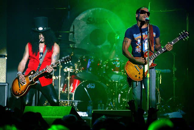 <p>Matthew Peyton/Getty </p> Slash and Lenny Kravitz performing in 2004