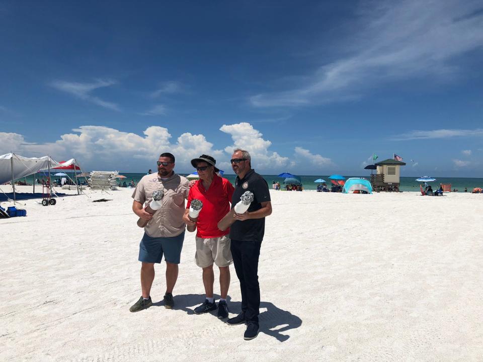 From left: J.P. Brooker, director of Florida Conservation at Ocean Conservancy; Stephen Leatherman, aka Dr. Beach; State Sen. Joe Gruters hold mock cigarette butts to celebrate a new law allowing local governments to ban smoking on Florida beaches.