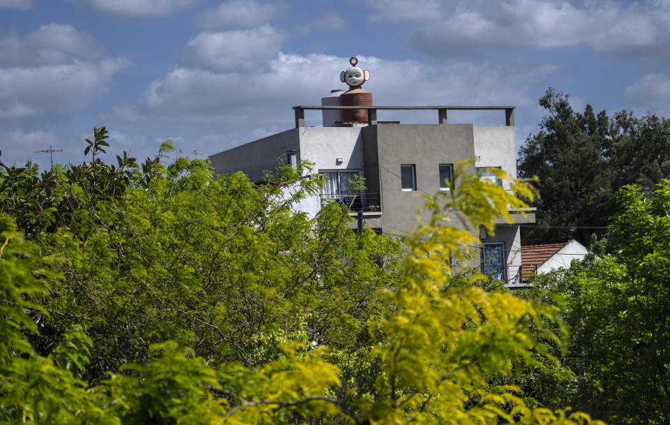 Una cabeza gigante de Po, el Teletubby rojo, transformada en la tapa de un tanque de agua puede ser vista por automovilistas que viajan por la carretera General Paz, en Ciudadela, Argentina, el lunes 17 de octubre de 2022. (AP Foto/Rodrigo Abd)