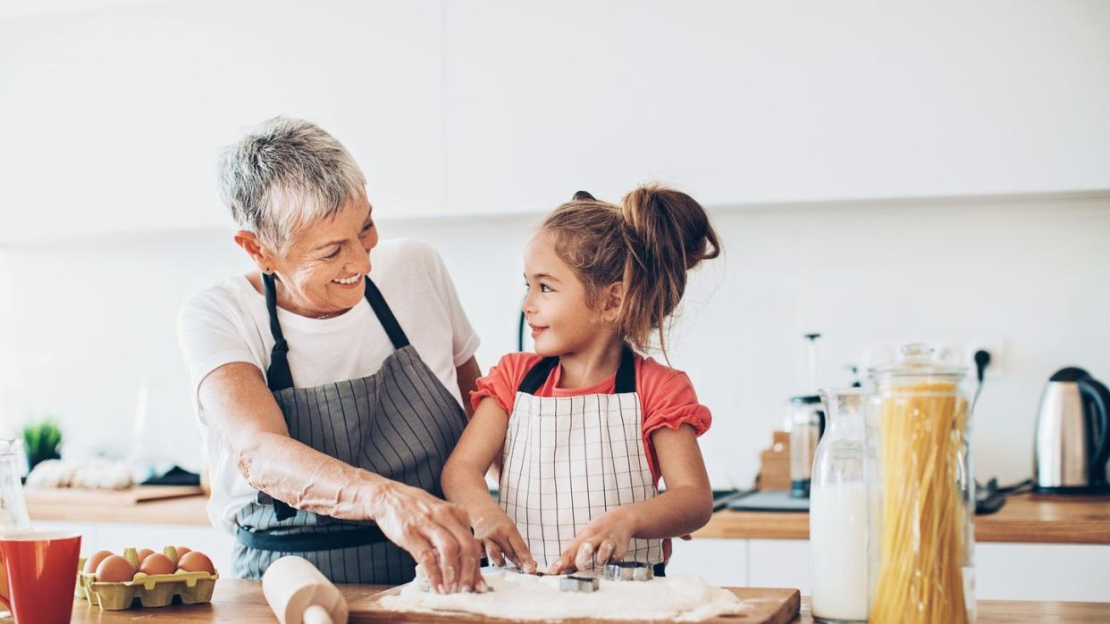 senior woman and a small girl preparing cookies