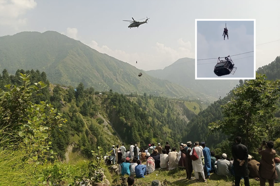 People watch as a soldier dangled from a helicopter during the rescue mission (AFP/Getty)