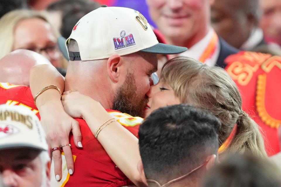 Travis Kelce and Taylor Swift kiss during the Chiefs' Super Bowl 58 celebration.