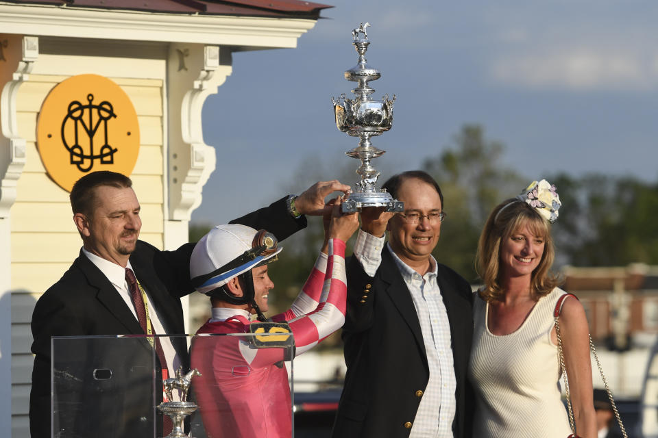 Rombauer trainer Michael McCarthy, left, jockey Flavien Prat, second from left, and horse owners John Fradkin and Diane Fradkin hold the trophy after winning the 145th Preakness Stakes horse race at Pimlico Race Course, Saturday, May 15, 2021, in Baltimore. (AP Photo/Will Newton)